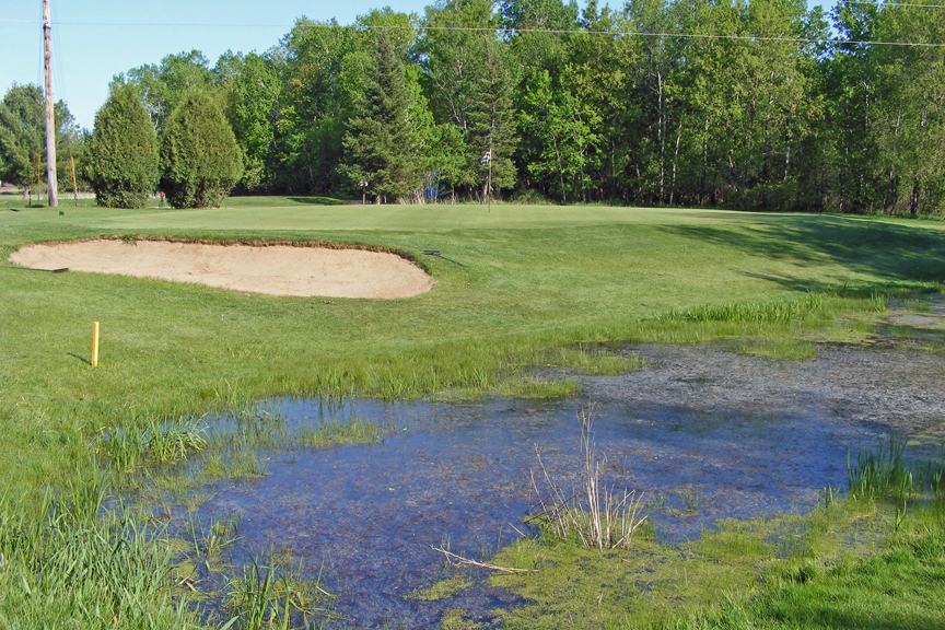 Pond on golf course with bunker